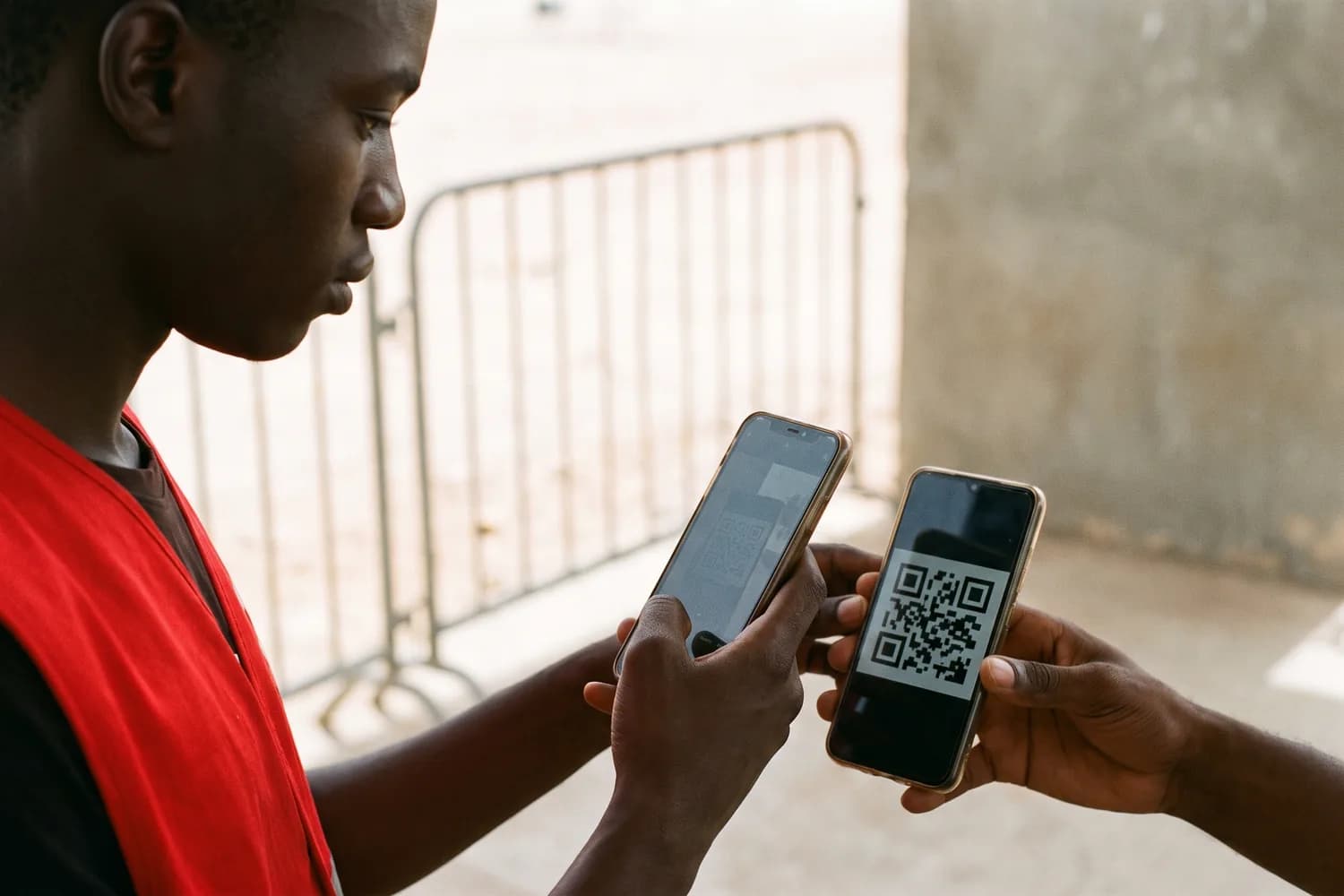 Un contrôleur pointe l'appareil photo de son téléphone vers le code affiché sur le téléphone d'un spectateur, à l'entrée.